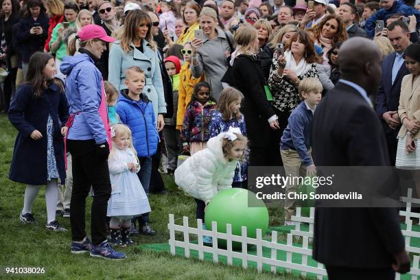 First lady Melania Trump watches as children participate in the lawn bowling activity during the 140th annual Easter Egg Roll on the South Lawn of...