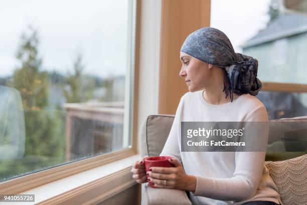 中年民族がんサバイバー窓際に座っているし、彼女の人生に反映しています。 - 女性患者 ストックフォトと画像