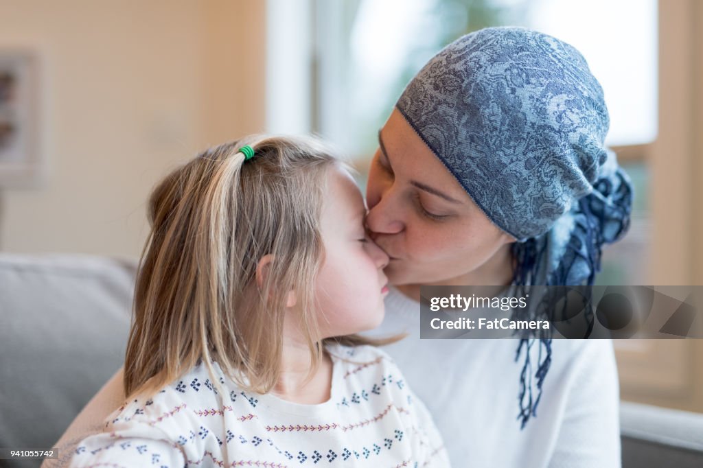 Jeune maman ethnique avec le cancer tient sa fille