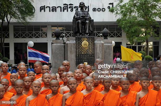 Thai Buddhist novices stand in the courtyard of the Siriraj Hospital where they came to offer prayers for the recovery of Thai King Bhumibol...