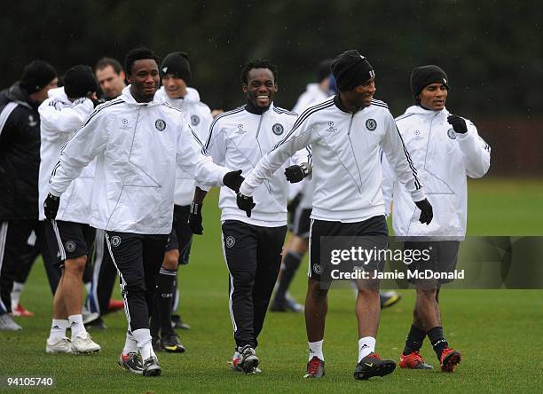 Didier Drogba of Chelsea shares a joke with team mates Michael Essien and Jon Obi Mikel during a Chelsea training session, ahead of their Champions...