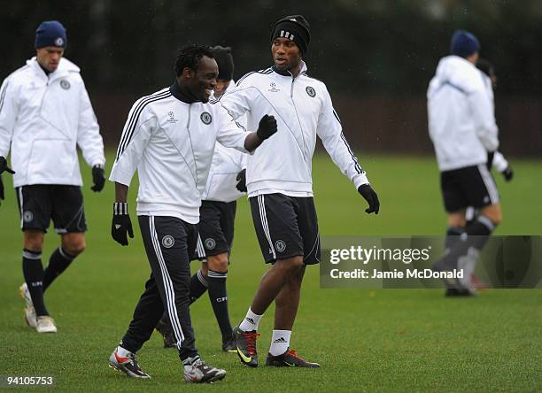 Didier Drogba of Chelsea shares a joke with team mate Michael Essien and Jon Obi Mikel during a Chelsea training session, ahead of their Champions...