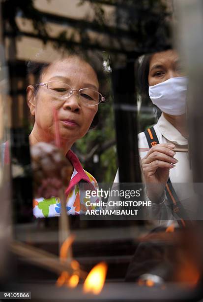 Thai well-wishers light incense sticks before offering prayers for the recovery of Thai King Bhumibol Adulyadej, at the Siriraj Hospital in Bangkok...
