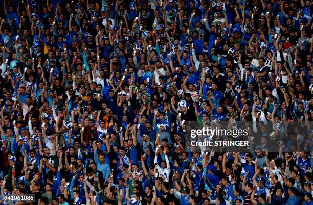 Esteghlal's supporters cheer for their team during the AFC Champions League football match between Iran's Esteghlal and Qatar's al-Rayyan at the...