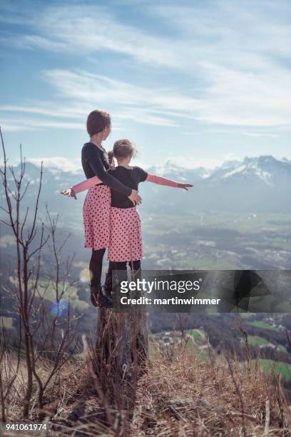 moeder en dochter wandelen met roze jurk rond bergen - martinwimmer stockfoto's en -beelden