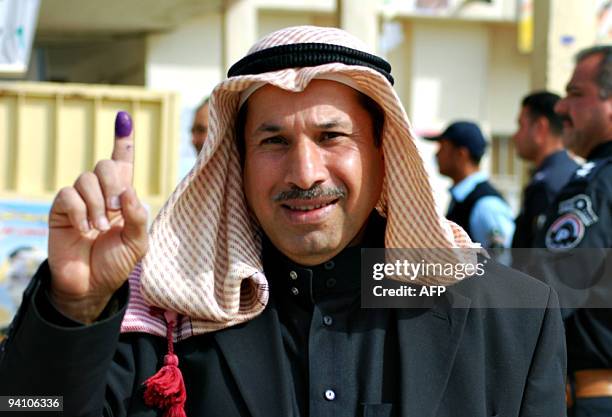 Sunni Muslim man shows his ink-stained finger after voting in the provincial elections in the western Anbar town of Ramadi, 100 kms from Baghdad on...