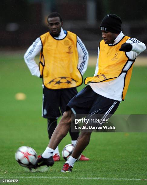 Didier Drogba is watched by Gael Kakuta of Chelsea during a Chelsea Training & Press Conference, ahead of their Champions League Group D match...