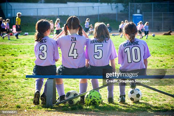 four girls [8] on the bench at soccer game - soccer shirt stock pictures, royalty-free photos & images