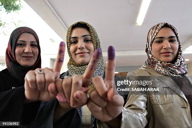 Iraqi women show off their ink stained fingers after voting in the provincial elections at the Salhiyeh polling station in central Baghdad on 31...