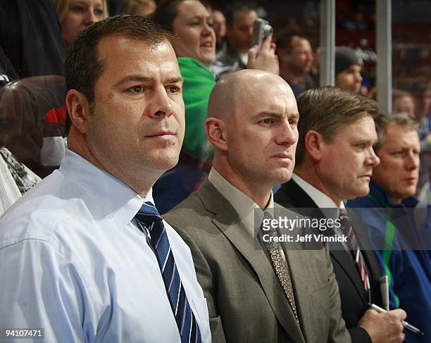 Head coach Alain Vigneault, assistant coaches Darryl Williams and Ryan Walter of the Vancouver Canucks look on from the bench during their game...