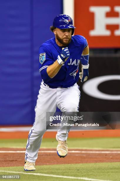 Russell Martin of the Toronto Blue Jays runs towards first base against the St. Louis Cardinals during the MLB preseason game at Olympic Stadium on...