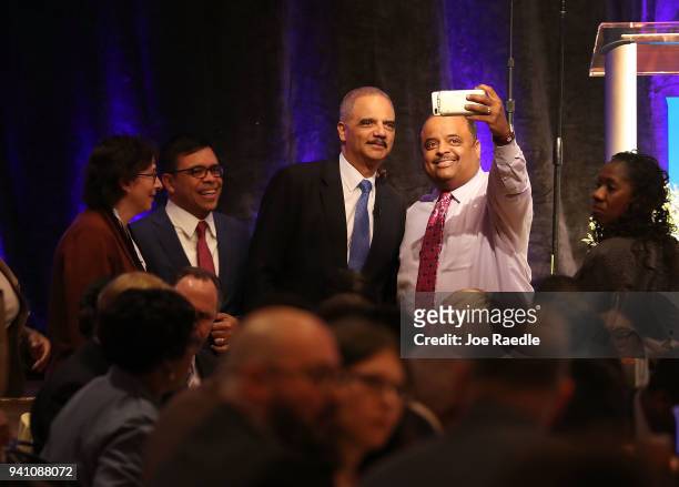 Eric Holder, Jr., the 82nd Attorney General of the United States, greets people before speaking during a symposium at the Peabody Hotel related to...