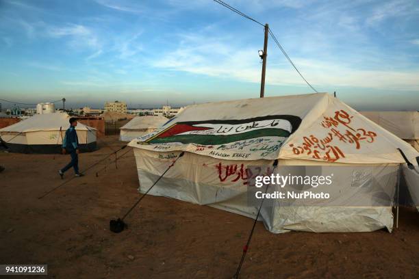 Palestinians walk next to tents on April 2, 2018 along the border with Israel east of Gaza City during a tent protest in support of Palestinian...