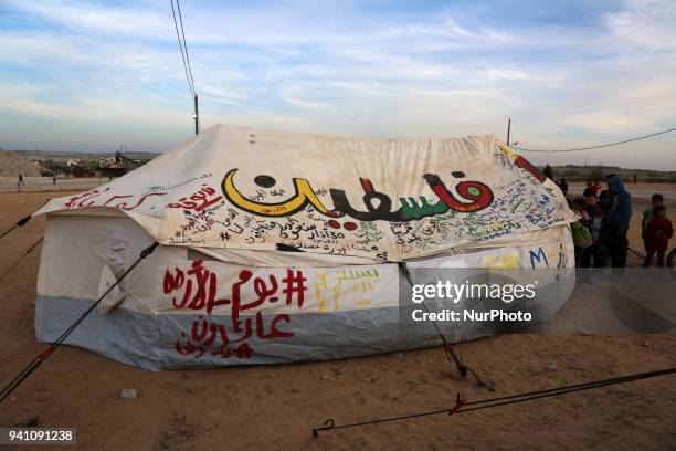 Palestinians walk next to tents on April 2, 2018 along the border with Israel east of Gaza City during a tent protest in support of Palestinian...