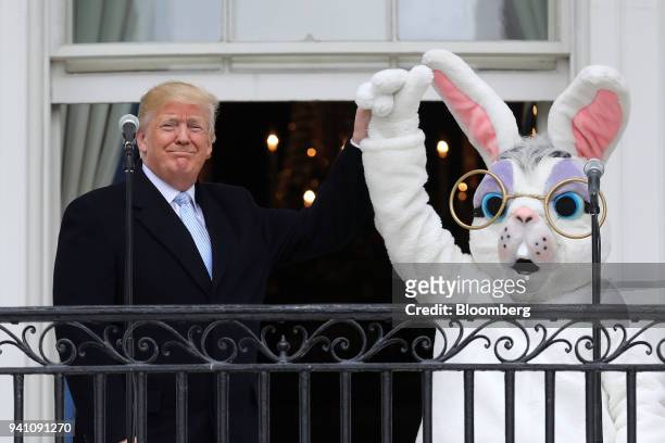 President Donald Trump raises the arm of a person in an Easter Bunny costume during the Easter Egg Roll on the South Lawn of the White House in...