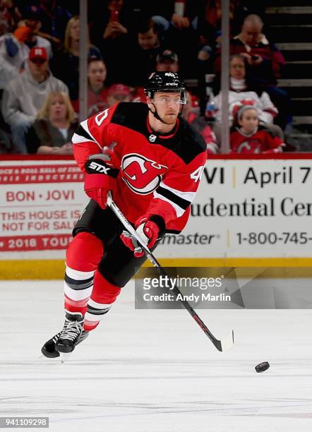 Michael Grabner of the New Jersey Devils plays the puck during the game against the New York Islanders at Prudential Center on March 31, 2018 in...