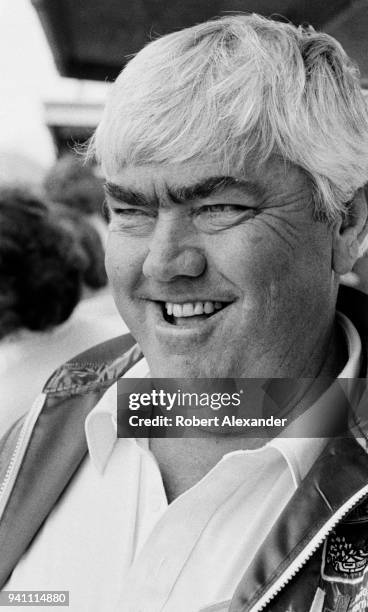 Racecar owner and former driver Junior Johnson watches his car circle the track during a practice session for the 1983 Daytona 500 stock car race at...