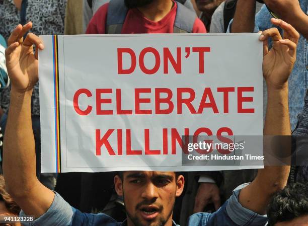 Supporter of Kashmir lawmaker, Engineer Abdul Rashid Sheikh holds a placard as he shouts slogan during a protest on April 2, 2018 in Srinagar, India....