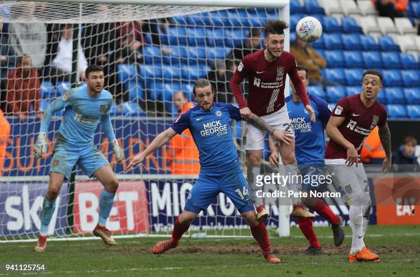Matt Grimes of Northampton Town heads the ball away from Jack Marriott of Peterborough United during the Sky Bet League One match between...