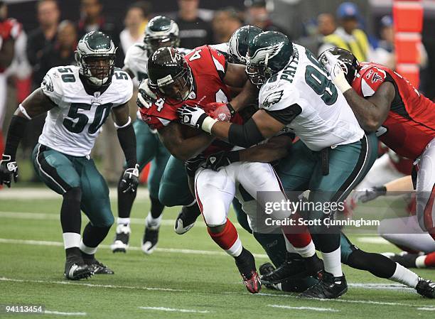 Jason Snelling of the Atlanta Falcons carries the ball against Mike Patterson of the Philadelphia Eagles at the Georgia Dome on December 6, 2009 in...