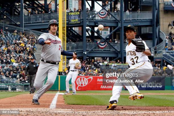 Joe Mauer of the Minnesota Twins slides in safe on a wild pitch against Edgar Santana of the Pittsburgh Pirates in the sixth inning during...