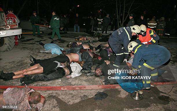 Rescuers carry dead bodies in front of the Lame Horse restaurant in Perm on December 5, 2009. Over 100 people were killed overnight when fireworks...