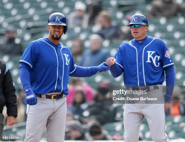 Cheslor Cuthbert of the Kansas City Royals receives a fist bump from first base coach Mitch Maier of the Kansas City Royals after hitting a single...