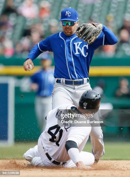 Victor Martinez of the Detroit Tigers beats second baseman Whit Merrifield of the Kansas City Royals to second base after Merrifield dropped the ball...