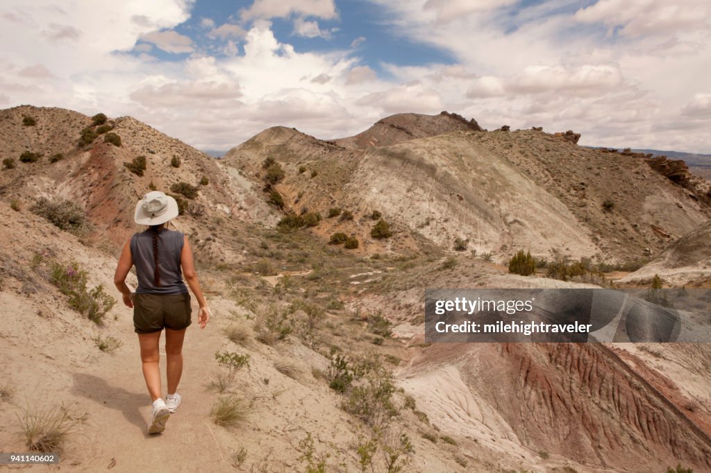 Woman hiker walks Fossil Discovery Trail Morrison Formation Dinosaur National Monument Utah