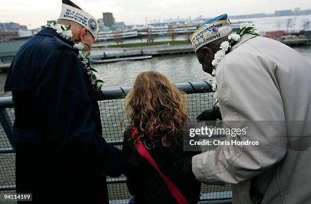 Clarke Simmons and Aaron Chabin , both of New York and both veterans of Pearl Harbor, show tourist Olivia Bennett of York, Pennsylvania where they...