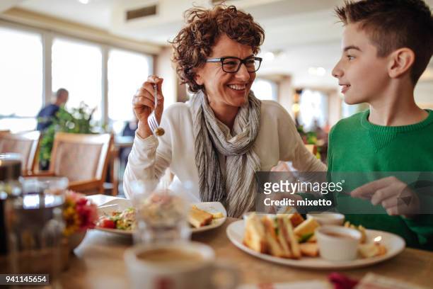 mother with her son in a restaurant - family eating out stock pictures, royalty-free photos & images