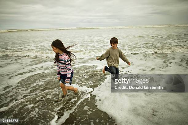 brother and sister at the beach - palmerston north nz bildbanksfoton och bilder