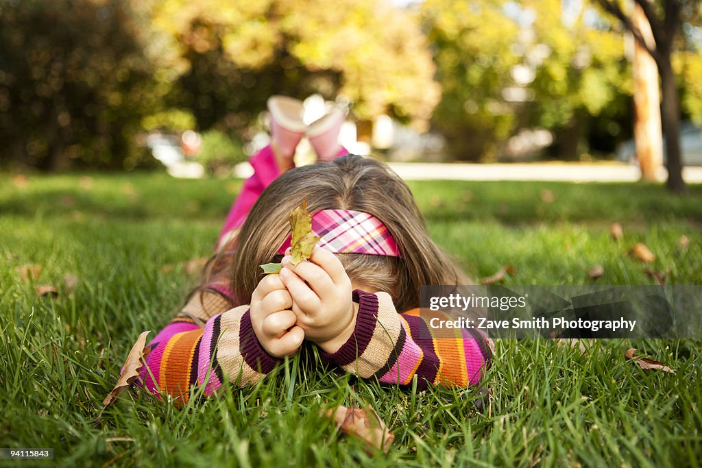 Young Girl on lawn holding leaf