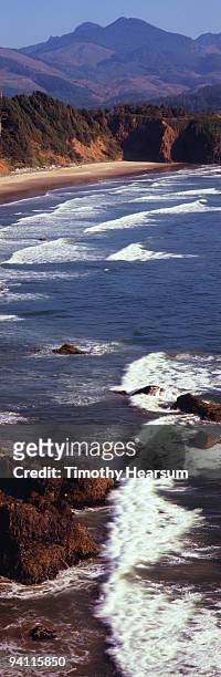 waves washing ashore,  beach and mountains beyond - timothy hearsum foto e immagini stock