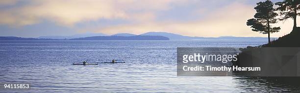 ocean kayakers with islands in background - timothy hearsum stock-fotos und bilder