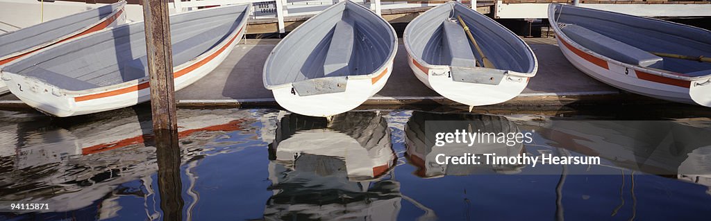 Rowboats on dock and reflected in water