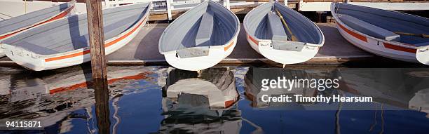 rowboats on dock and reflected in water - timothy hearsum stock pictures, royalty-free photos & images