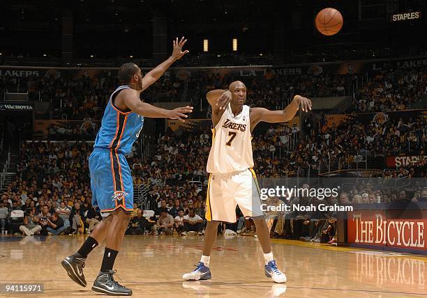 Lamar Odom of the Los Angeles Lakers passes the ball around D.J. White of the Oklahoma City Thunder during the game on November 22, 2009 at Staples...