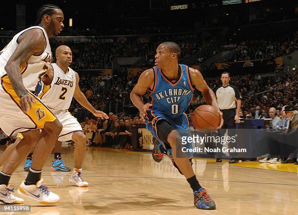 Russell Westbrook of the Oklahoma City Thunder drives the ball against Josh Powell and Derek Fisher of the Los Angeles Lakers during the game on...