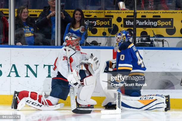 Philipp Grubauer of the Washington Capitals and Carter Hutton of the St. Louis Blues talk during warmups at Scottrade Center on April 2, 2018 in St....