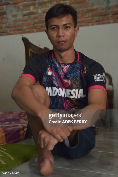 This picture taken on February 3, 2018 shows Eman Sulaeman posing while resting with his friends and teammates at a house ahead of a futsal match in...