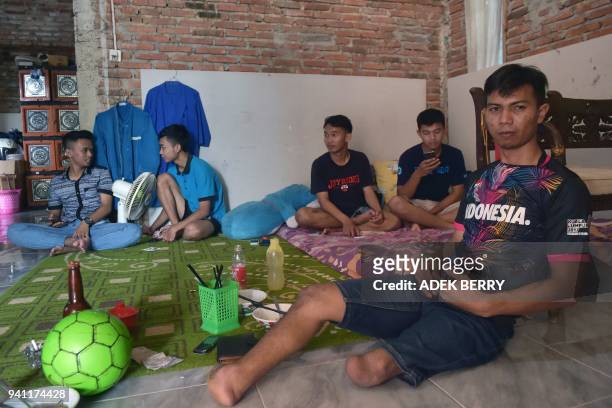 This picture taken on February 3, 2018 shows Eman Sulaeman resting with his friends and teammates at a house ahead of a futsal match in Indramayu,...