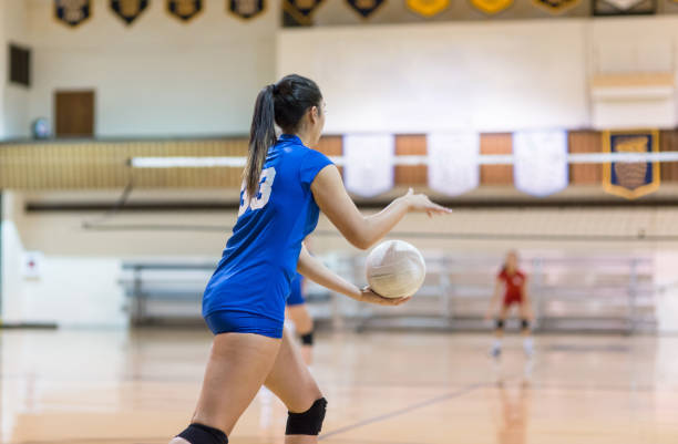 teenage volleyball player prepares to serve... - girls volleyball stock pictures, royalty-free photos & images
