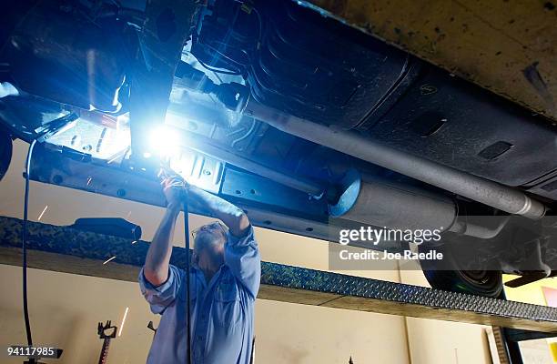 Kevin Doyle from Mad Hatter Muffler shop works on replacing a catalytic converter on a truck on December 7, 2009 in Davie, Florida. The Environmental...