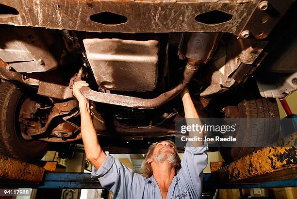 Kevin Doyle from Mad Hatter Muffler shop works on replacing a catalytic converter on a truck on December 7, 2009 in Davie, Florida. The Environmental...