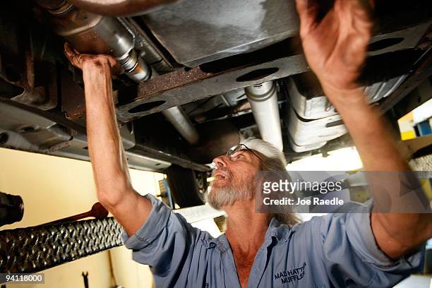 Kevin Doyle from Mad Hatter Muffler shop works on replacing a catalytic converter on a truck on December 7, 2009 in Davie, Florida. The Environmental...