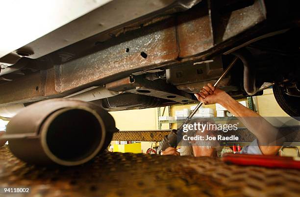 Kevin Doyle from Mad Hatter Muffler shop works on replacing a catalytic converter on a truck on December 7, 2009 in Davie, Florida. The Environmental...