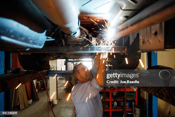 Kevin Doyle from Mad Hatter Muffler shop works on replacing a catalytic converter on a truck on December 7, 2009 in Davie, Florida. The Environmental...