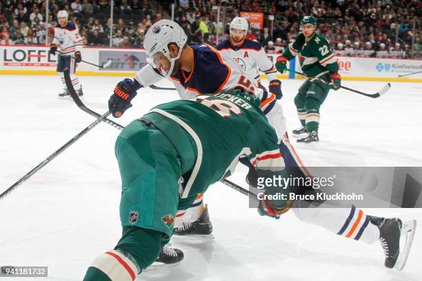 Jason Zucker of the Minnesota Wild defends Darnell Nurse of the Edmonton Oilers during the game at the Xcel Energy Center on April 2, 2018 in St....