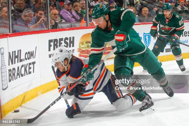 Charlie Coyle of the Minnesota Wild and Pontus Aberg of the Edmonton Oilers battle for the puck during the game at the Xcel Energy Center on April 2,...